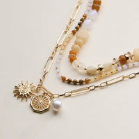Layered Beaded and Chain Necklace with Sun and Pearl Charms – Gold Accent Design