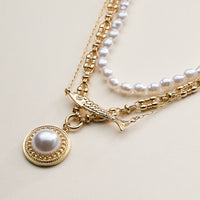 Layered Pearl and Chain Necklace with Round Pendant – Fish Link Detail