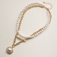 Layered Pearl and Chain Necklace with Round Pendant – Fish Link Detail
