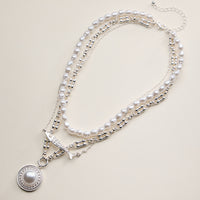 Layered Pearl and Chain Necklace with Round Pendant – Fish Link Detail